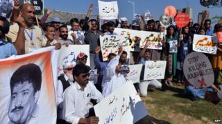 Пакистанские журналисты держат плакаты и фотографии с изображением телевизионного журналиста Geo Хамида Мира во время акции протеста против нападения на Мир боевиков в Исламабаде 23 апреля 2014 года