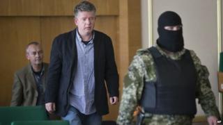 European military observers are led by a gunman in Sloviansk. Photo: 27 April 2014