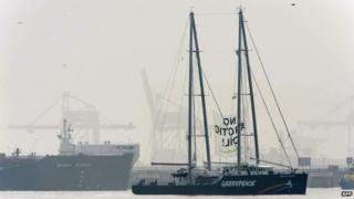 A banner reading "No Arctic oil!" hangs from Greenpeace's Rainbow Warrior docked next to the Russian oil tanker Mikhail Ulyanov (L) at the harbour of Rotterdam