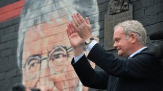 Martin McGuinness in front of Gerry Adams mural