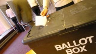 Woman casting vote in ballot box