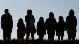 Silhouettes of a group of people in a line