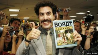 Sasha Baron Cohen dressed as Borat with fans behind him