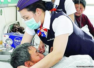 A nurse wearing air hostess-style uniform tends to a patient