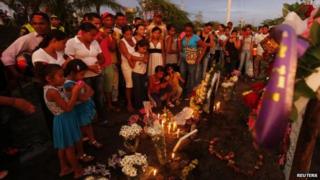 Relatives and residents light candles as they pay respect at the site of a bus accident in Fundacion, northern Colombia, May 19, 2014