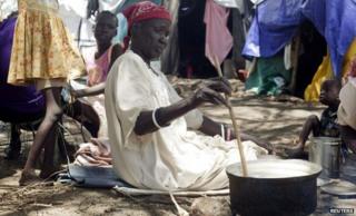 South Sudanese woman displaced by recent fighting prepares a meal