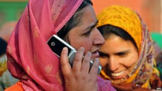 A Kashmiri woman speaks on her mobile phone