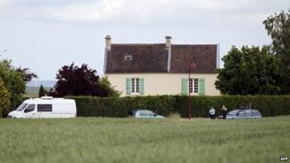 French gendarmes stand in front of a house where the mayor of Bretteville-le-Rabet was found dead