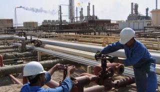 Iraqi workers operate the valves at the oil fields of Rumailah, Iraq, in August 2005