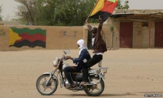 A Tuareg man waves the flag of the National Movement for the Liberation of Azawad (MNLA) in Kidal, northern Mali.