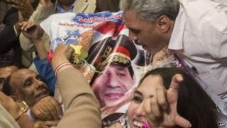 Egyptian journalists and officials kiss a picture of Abdul Fattah al-Sisi after he is declared the new president (3 June 2014)