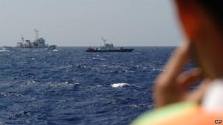 Picture taken from a Vietnam Coast Guard ship on May 14, 2014 shows a China Coast Guard ship (L) chasing a Vietnam Coast Guard vessel near to the site of a Chinese drilling oil rig being installed at the disputed water in the South China Sea