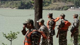 Indian rescue personnel gather on the banks of the Beas River during a search operation in Kullu on June 9, 2014.