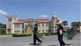 City workers carrying brooms and baskets inside the Government House compound on 31 May.