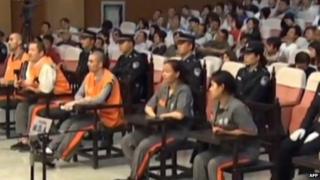 This screen grab taken from state broadcaster China Central Television (CCTV) footage on 16 June 2014 shows six of the eight prisoners (seated - in orange and brown) standing at the Intermediate People's Court in the Xinjiang capital Urumqi for the trial of those accused in the attack in October 2013 in Beijing's Tiananmen Square that killed two tourists
