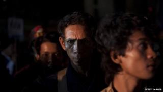 Cambodian workers get off a bus after crossing the Thai border on June 17