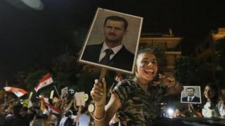 A supporter of Syrian President Bashar Assad celebrates his re-election on 4 June, 2014.