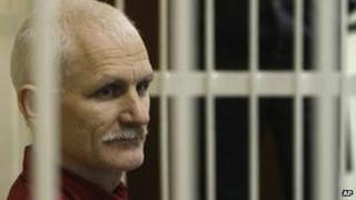 Ales Belyatski sits in a cage in court in Minsk, 24 November 2011