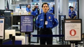 A Transportation Security Administration (TSA) agent waits for passengers to use the TSA PreCheck lane being implemented by the Transportation Security Administration at Miami International Airport 4 October 2011