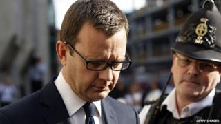 Andy Coulson leaves the Old Bailey, watched by a police officer