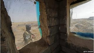 Iraqi forces patrol a checkpoint in Taza Khormato, south of Kirkuk, on 21 June 2014