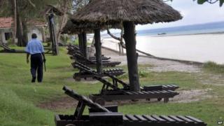 Охранник проходит мимо пустых шезлонгов с видом на Индийский океан на курорте в городе Диани, к югу от Момбасы, на побережье Кении. Четверг, 22 мая 2014 г.