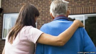 A woman helps and elderly man