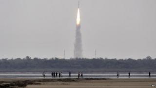 Indians watch the Polar Satellite Launch Vehicle (PSLV-C23) rocket lifting off from the east coast island of Sriharikota, India, Monday, June 30, 2014