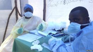 Government health workers are seen during the administration of blood tests for the Ebola virus in Kenema, Sierra Leone, on 25 June 2014