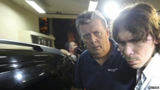 Ray Whelan (left) is escorted to a police station in Rio de Janeiro. Photo: 7 July 2014