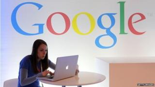 Woman on laptop in front of google sign