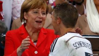 German Chancellor Angela Merkel congratulates Bastian Schweinsteiger of Germany during the medal ceremony after the 2014 FIFA World Cup Brazil Final match between Germany and Argentina at Maracana in Rio de Janeiro, Brazil, 13 July 2014