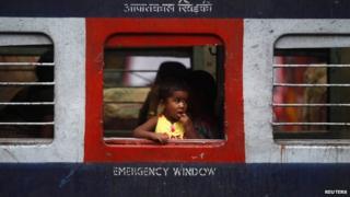 India girl looks out of a window of a passenger train
