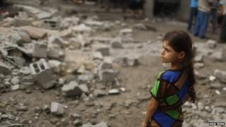 A Palestinian girl looks at houses which witnesses said were damaged in an Israeli air strike that killed two children, in the northern Gaza Strip, 24 July 2014