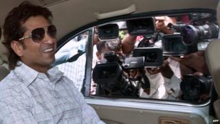 Indian cricketer Sachin Tendulkar smiles as he arrives at Parliament House in New Delhi, July 2012