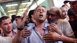 Palestinian man mourns death of a relative at Beit Lahiya mortuary 13/08/2014