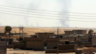 Smoke rises in distance after a US air strike near Mosul dam on 17 August 2014