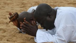Либерийцы молятся на пляже 20 августа 2014 года в Монровии за помощь в преодолении кризиса, вызванного вирусом Эбола