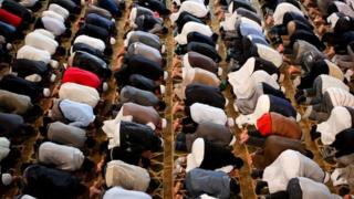 Мужчины на коленях в молитве в мечети