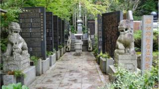 Stone-carved guardian dogs sit at the entrance of a memorial compound honoring World War II-era war criminals in Koyasan Okuno-in temple in Koya town, Wakayama prefecture, central Japan, Wednesday, 27 Aug 2014.