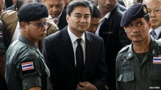 Democrat Party leader and former prime minister Abhisit Vejjajiva (centre) arrives at Bangkok criminal court in Bangkok, 12 December 2013