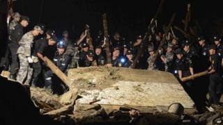 Rescue workers lift a wall that collapsed after a landslide hit Yingping village in Fuquan city in southwest China's Guizhou province on Thursday 28 August, 2014