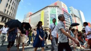 14 июня 2014 года люди гуляют в токийском торговом районе Гиндза.