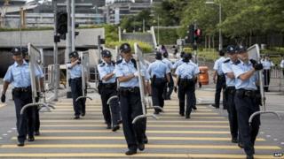 Полицейские несут барьеры возле правительственных учреждений Гонконга