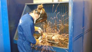 Woman using angle grinder