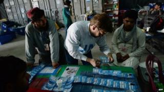 Afghan election commission workers sort ballot papers during an audit of the presidential run-off vote in the country"s general election at a counting centre in Kabul on August 25, 201