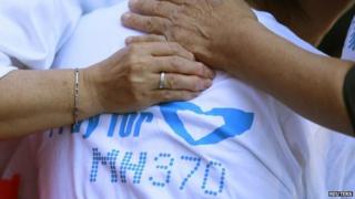 Family members of passengers onboard the missing Malaysia Airlines Flight MH370 comfort a crying woman as they gather to pray at Yonghegong Lama Temple in Beijing on 8 September 2014