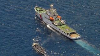 A China Coast Guard ship (R) and a Philippine supply boat engage in a stand off as the Philippine boat attempts to reach the Second Thomas Shoal, a remote South China Sea a reef claimed by both countries, on 29 March 2014