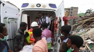 Спасатели несут выжившего в машину скорой помощи в Лагосе, Нигерия, 13 сентября 2014 года.
