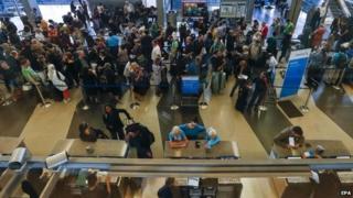 Travelers wait on line to book and reschedule travel plans after flights were delayed or cancelled at O'Hare International Airport in Chicago, Illinois, USA, 26 September 2014.